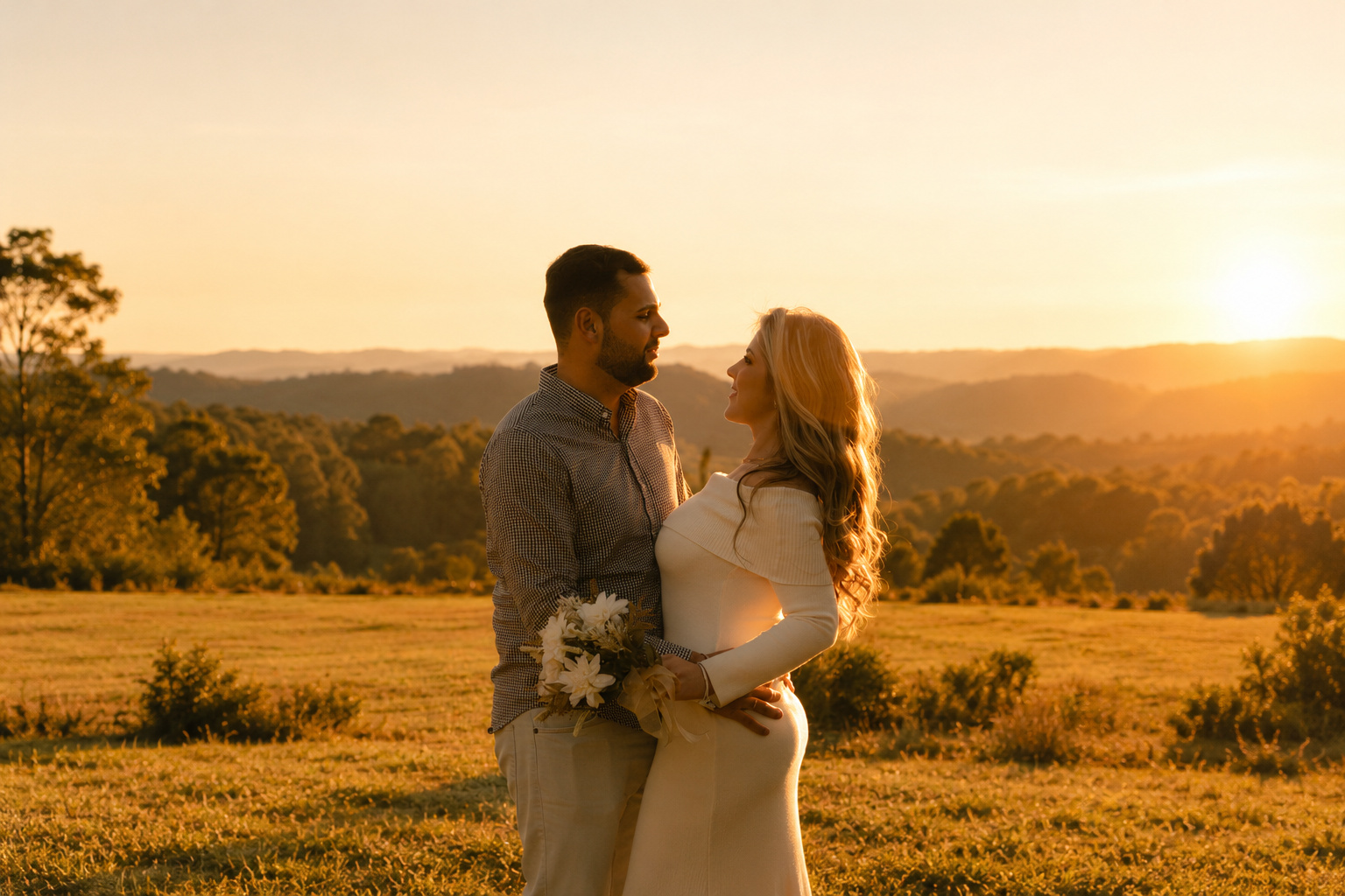 Casal se olhando em um campo ao pôr do sol