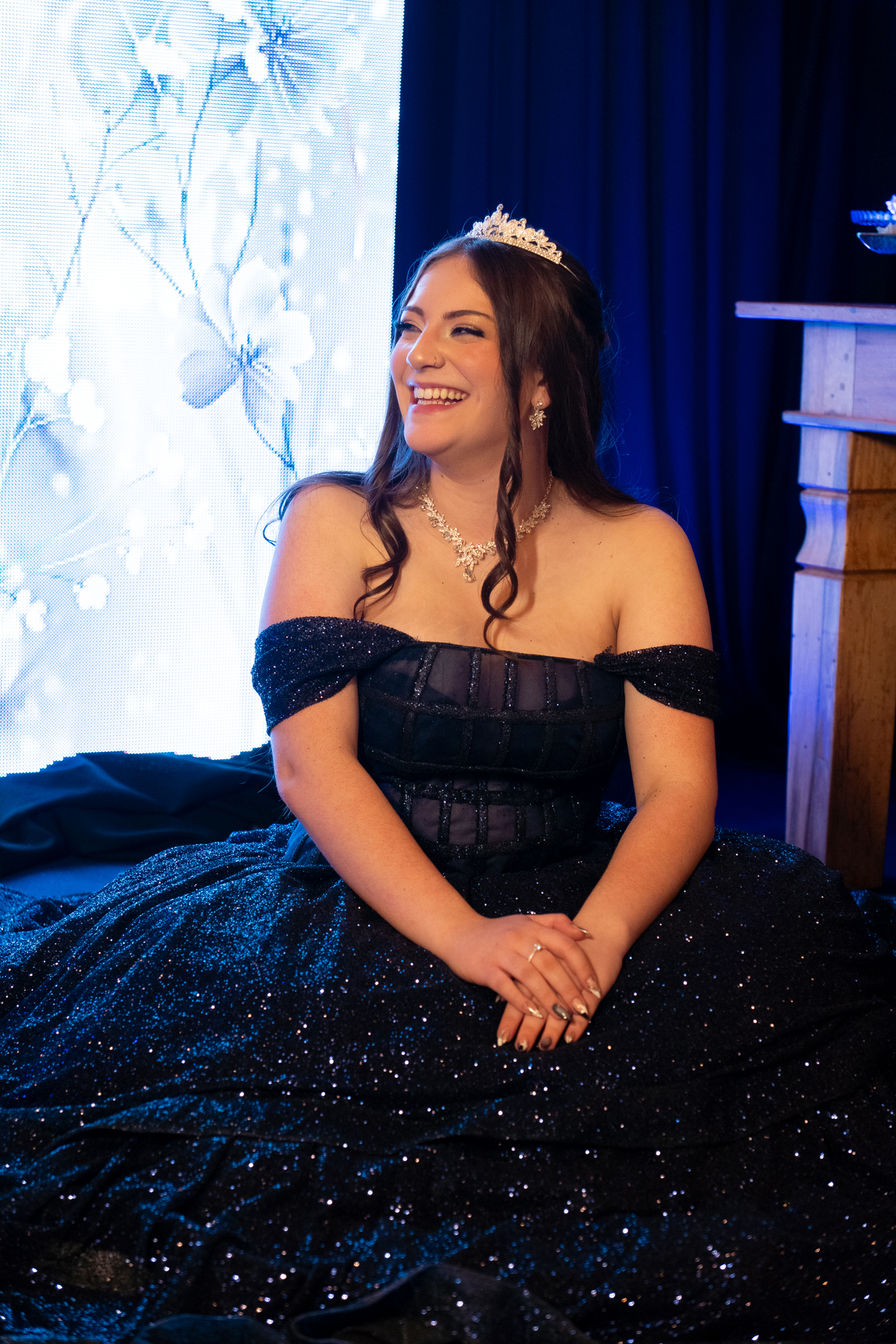 Debutante rindo, sentada com o vestido aberto no chão