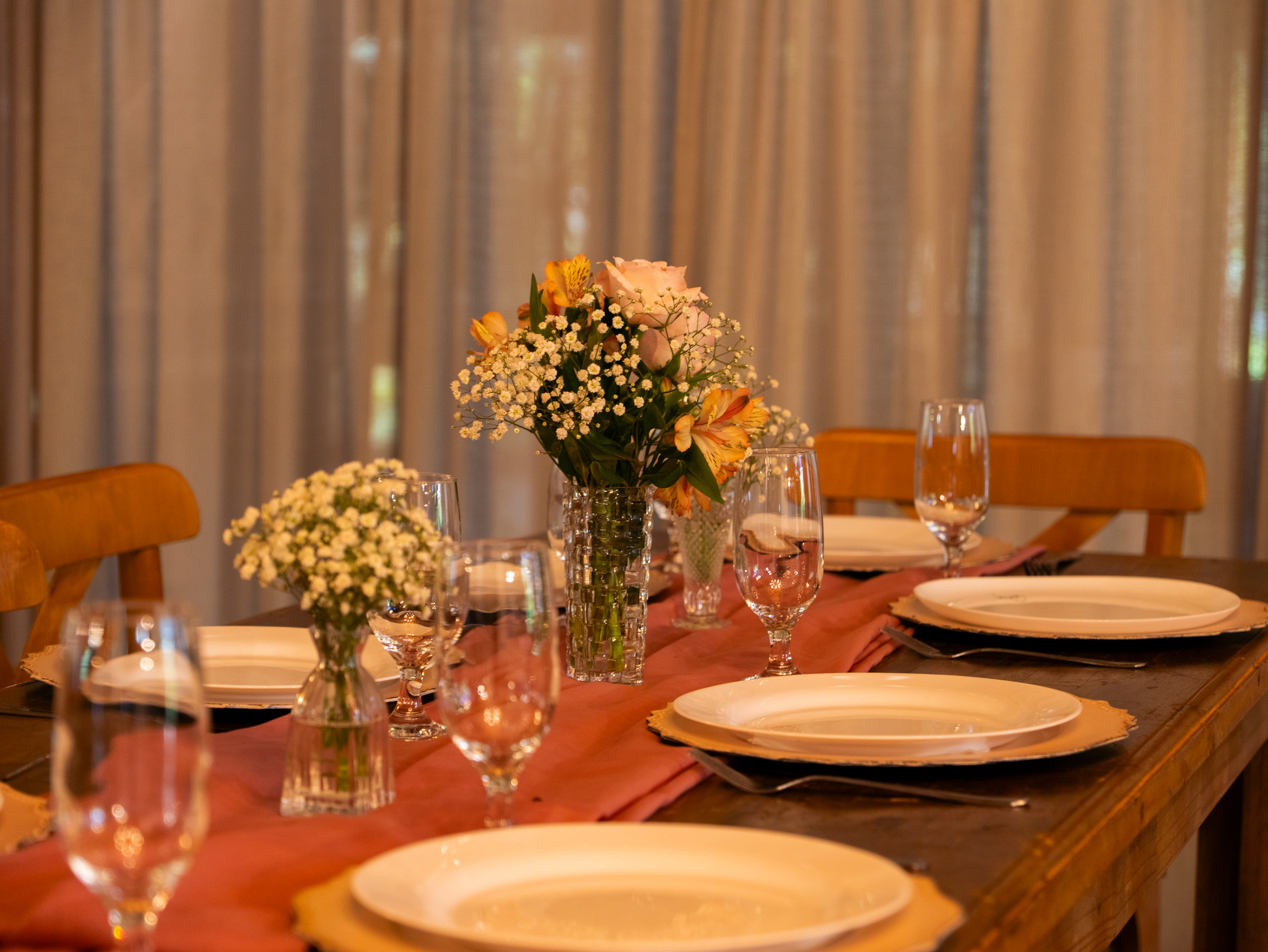 Mesa posta com pratos, taças e arranjos de flores
