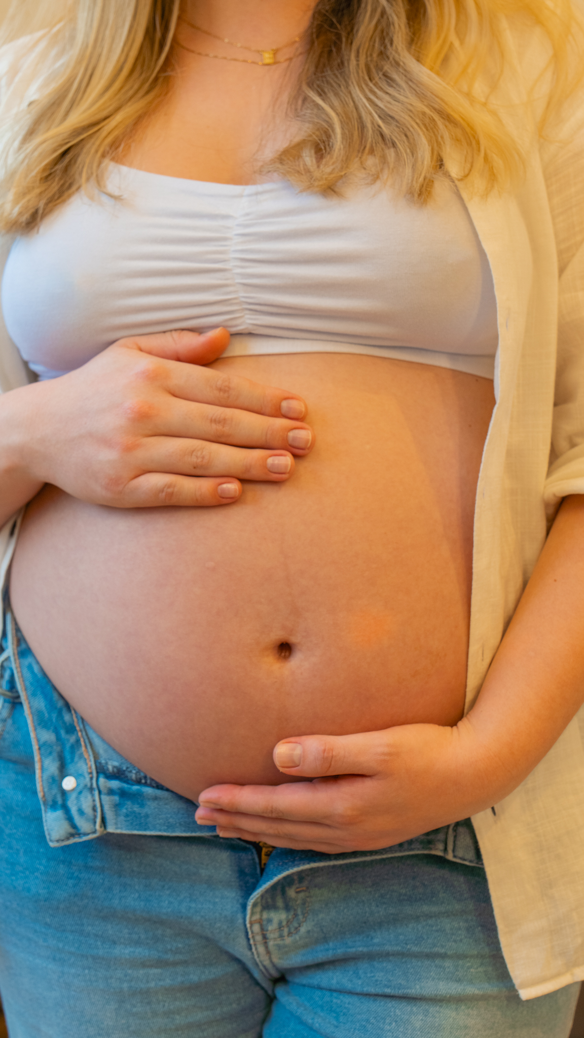Mãos da gestante sobre a barriga