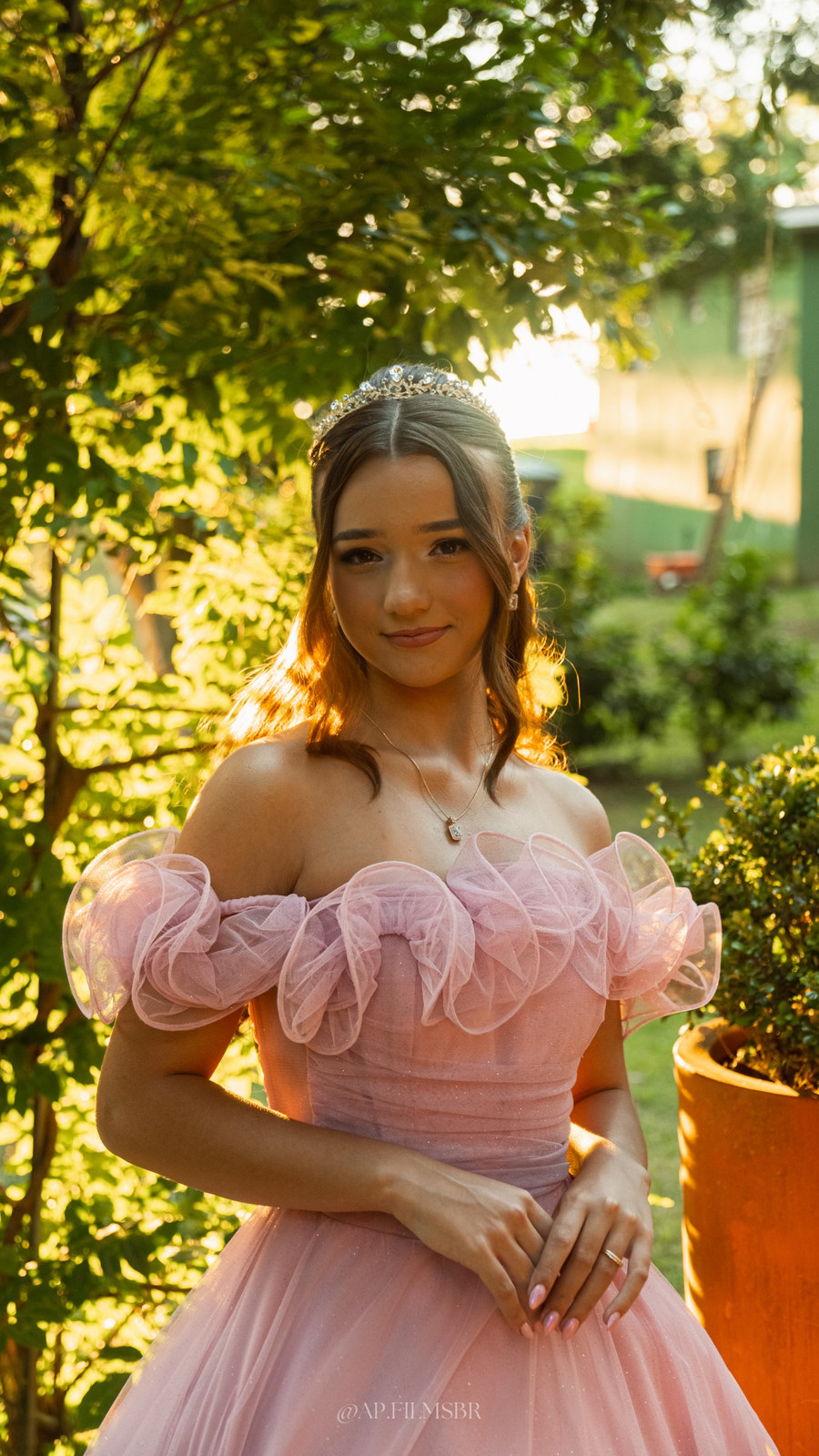Debutante de vestido rosa e tiara na luz do fim de tarde