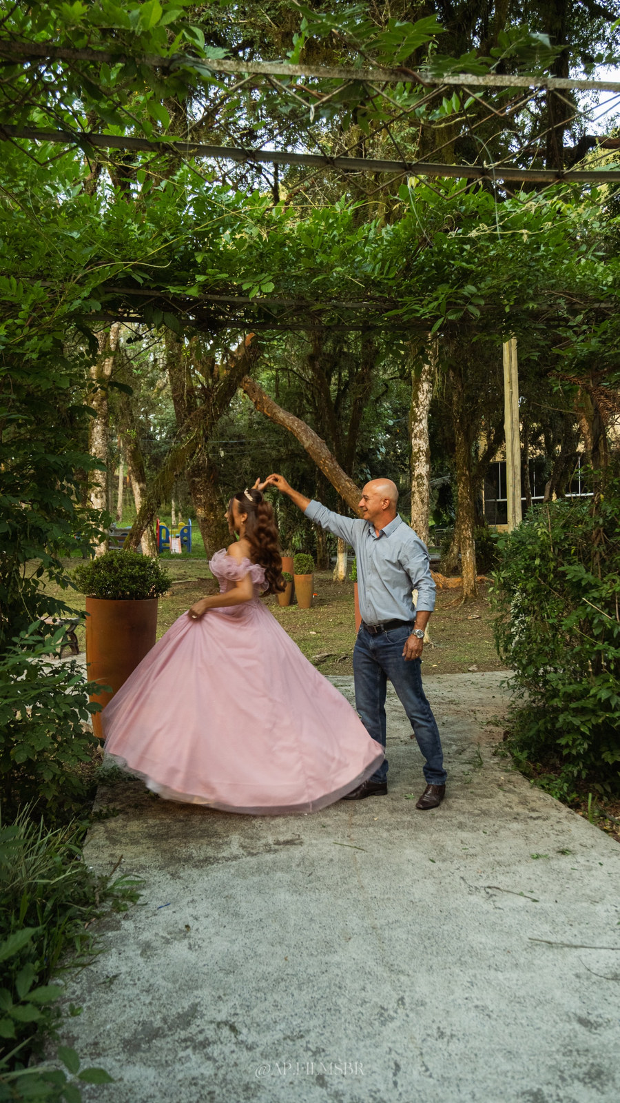 Debutante dançando com o pai sob um caramanchão