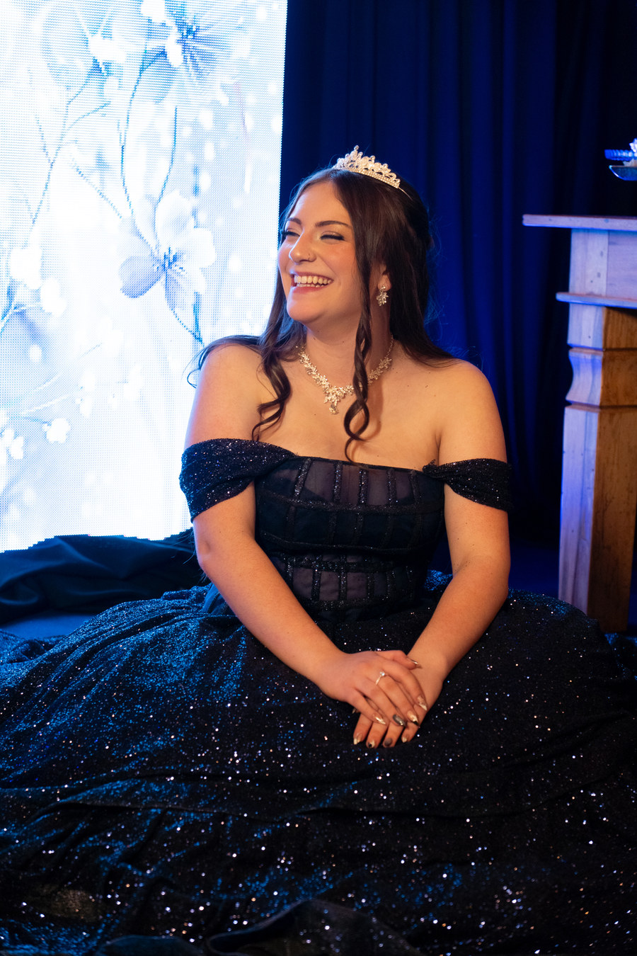 Debutante rindo de olhos fechados, sentada
