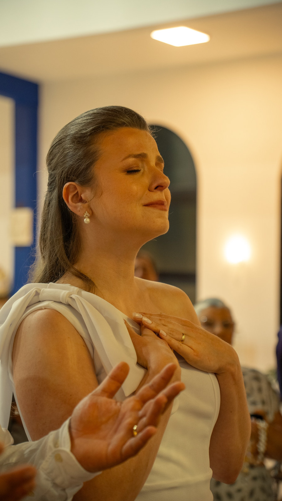 Noiva emocionada, com as mãos no peito, durante a cerimônia