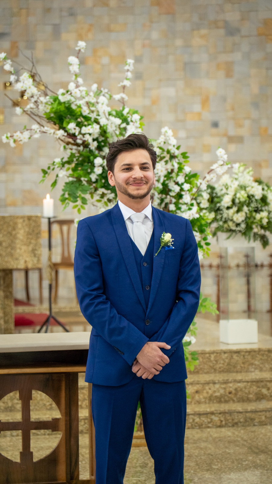 Noivo sorrindo no altar, à espera da noiva