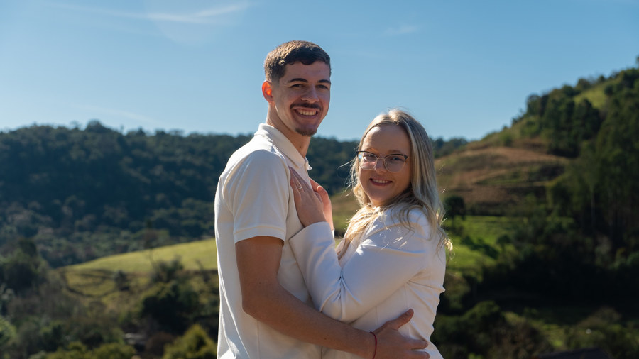 Casal abraçado com montanhas ao fundo