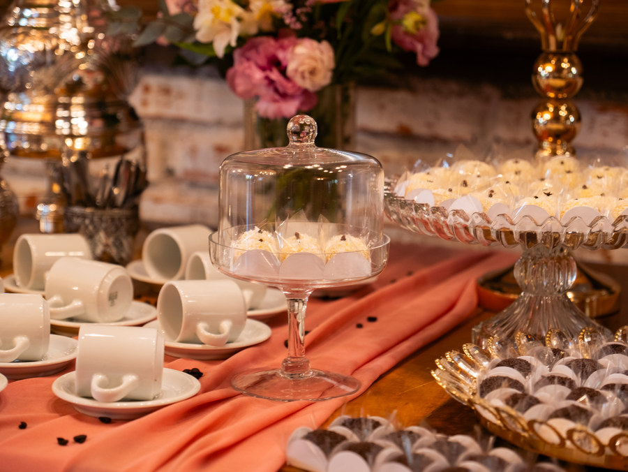 Detalhe da mesa de doces, com cúpula de vidro e xícaras de café