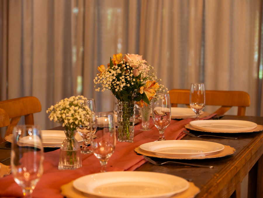 Mesa posta com pratos, taças e arranjos de flores
