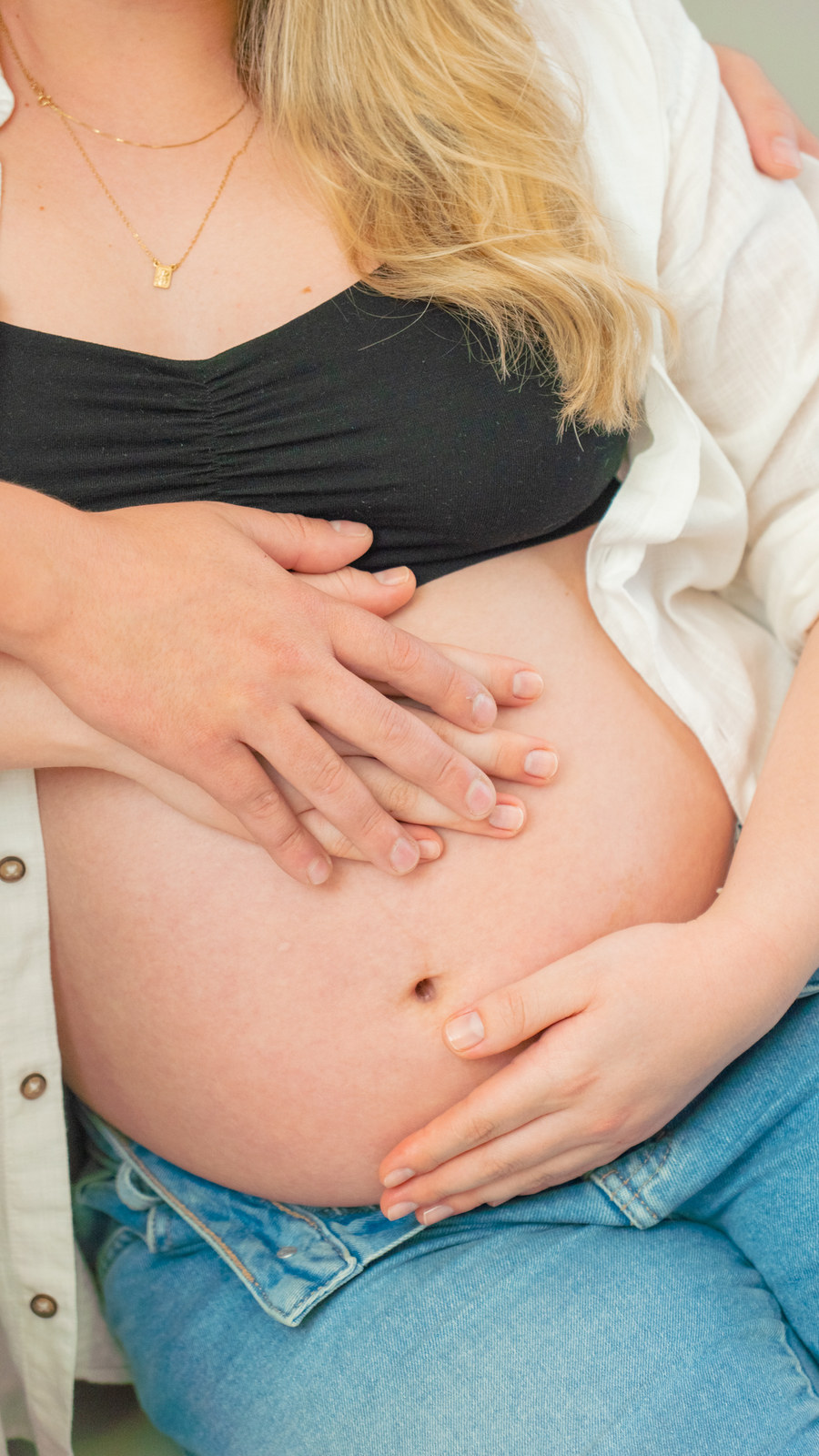 Mãos do casal juntas sobre a barriga