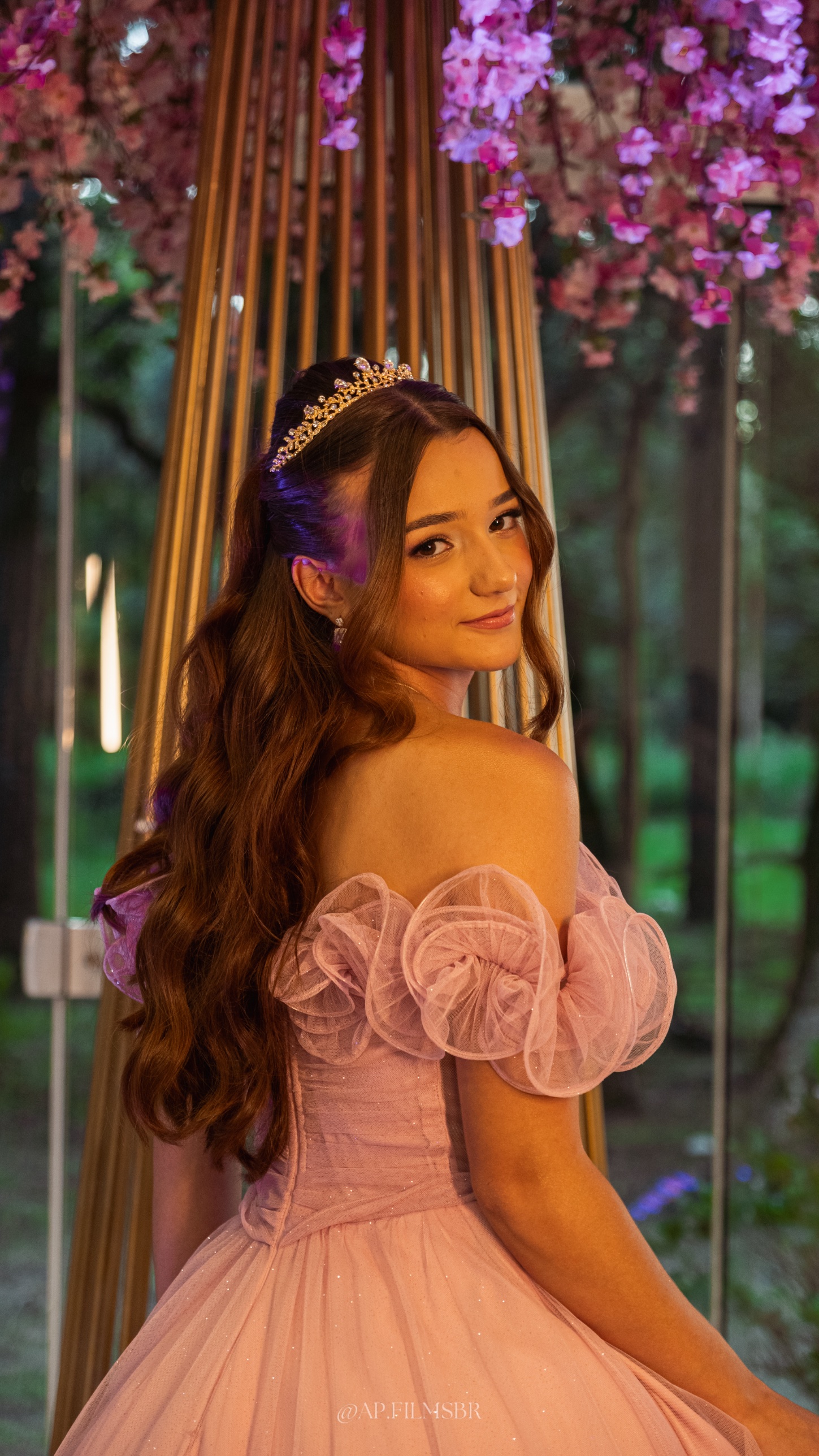 Debutante de vestido rosa e tiara, olhando por cima do ombro